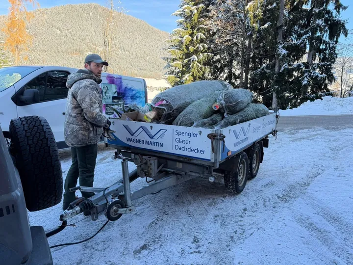 Für Charitree verpackte Christbäume auf einem beladenen Anhänger